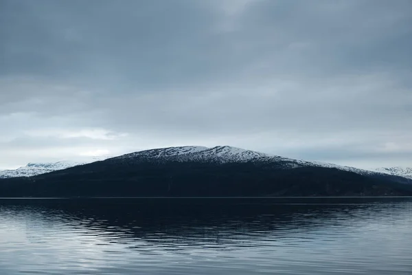 Snødekte fjelltopper som reflekteres i saltvannet rett under – stockfoto