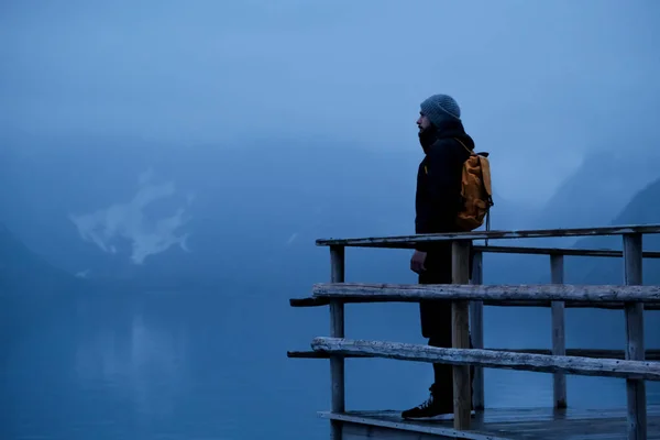 Gece Lofoten Reine arka planda duran sarı bir sırt çantası ile Gezgin adam — Stok fotoğraf