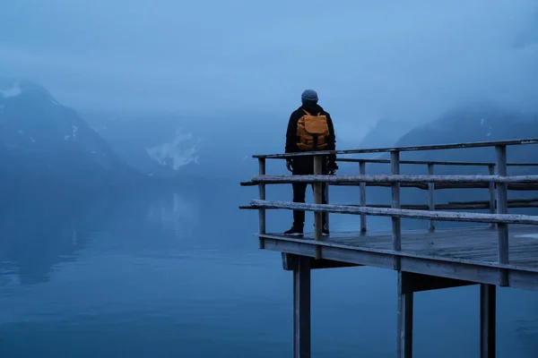 Gece Lofoten Reine arka planda duran sarı bir sırt çantası ile Gezgin adam — Stok fotoğraf