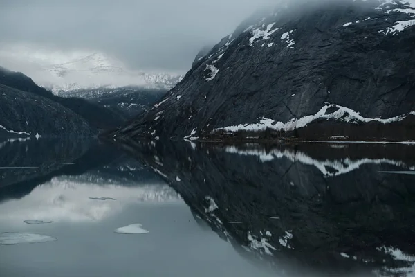Snødekte fjelltopper som reflekteres i saltvannet rett under royaltyfrie gratis stockbilder