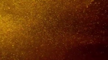 Soyut hareket arka planı altın parçacıkları parlıyor. Parıldayan parçacıklar