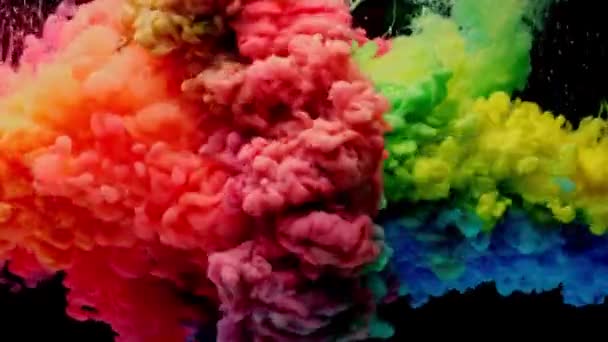 Colorato vernice arcobaleno gocce dall'alto mescolando in acqua. Inchiostro vorticoso sott'acqua. — Video Stock