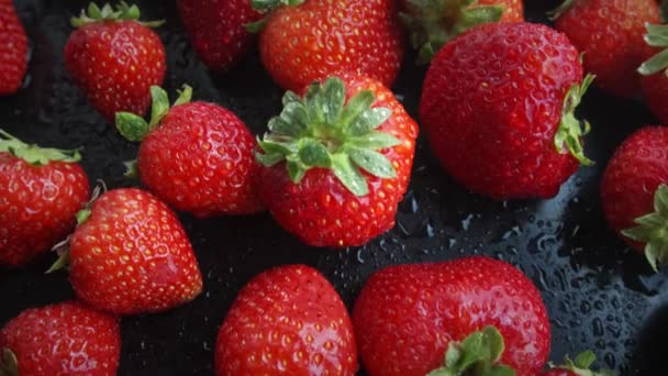 Erdbeeren rotieren auf schwarzem Hintergrund. Natürliche Produkte sind umweltfreundlich. — Stockvideo