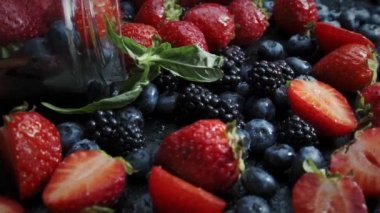 Kara arka planda yabani orman meyveleri, çilek, yabanmersini ve böğürtlen koleksiyonu.