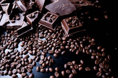 Beton arka planda koyu organik çikolata ve kahve çekirdekleri