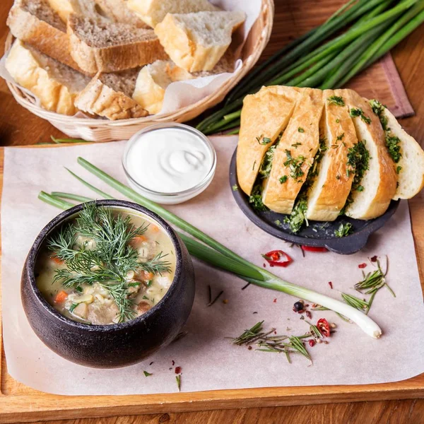 Sarımsak ekmek ve yeşil soğan ile bir tencerede mantar çorbası