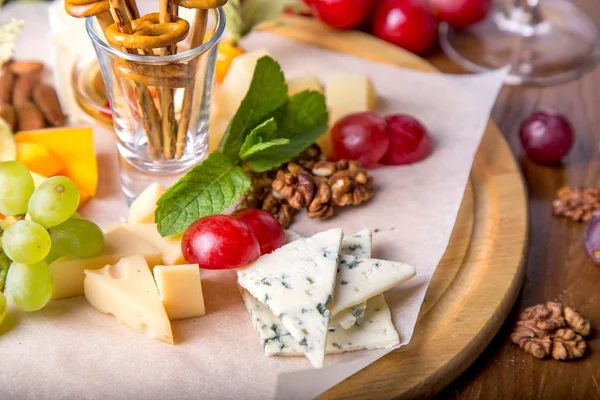 Üzüm, reçel ve bir ahşap tahta üzerinde fındık ile peynir tabakları servis. Lezzetli soğuk meze