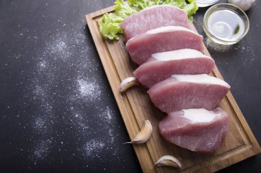 Ahşap tahta üzerinde taze Çiğ domuz fileto dilimleri. Üstten görünüm