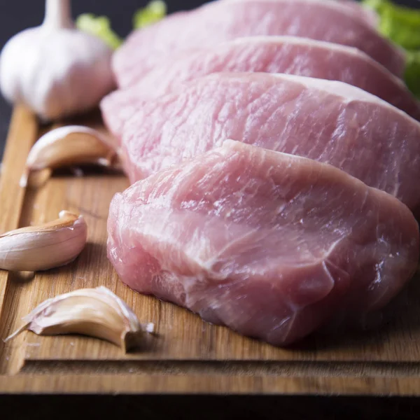 Çiğ et ahşap tahta üzerinde taze sarımsak ile