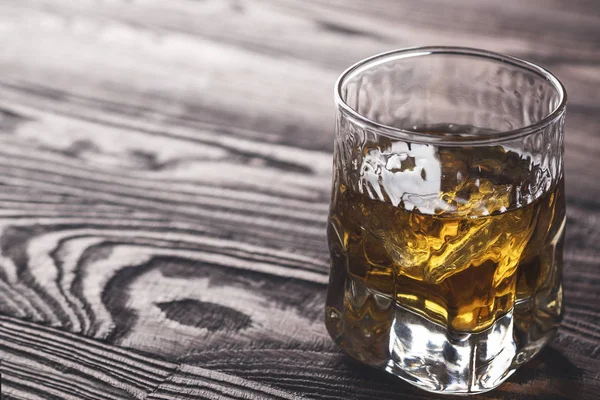 Whiskey med is i ett glas på rustika trä bakgrund. Kopiera utrymme — Stockfoto