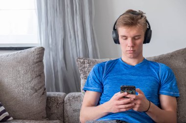 Evde telefon kullanan genç bir adam. Metin uzayı