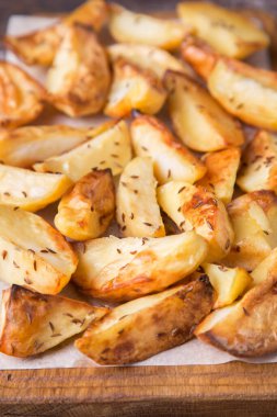 Tahtada kimyonlu kızarmış patates. Lezzetli kızarmış patates. Üst görünüm