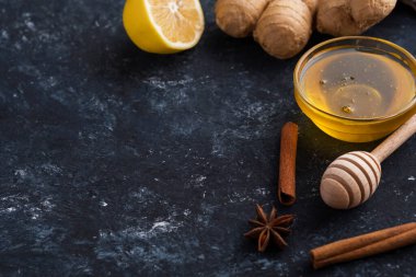 Doğal sıcak içecekle savaşmak için gerekli malzemeler. Limonlar, zencefil ve bal ahşap arka planda. Boşluğu kopyala.