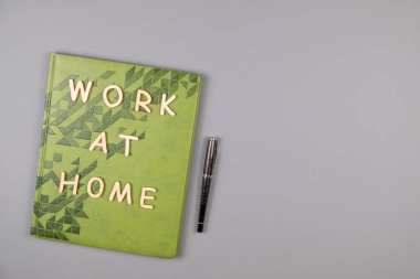 Gri arka planda tahta harfler, defter ve kalemle yazılmış ev kelimelerinde çalış. Boşluğu kopyala