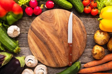 Taze sebze ve bıçakla dolu boş kesim tahtası. Üst görünüm