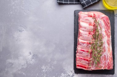 Kemik üstünde çiğ domuz eti ve siyah taşın üstünde biberiye. Metin uzayı