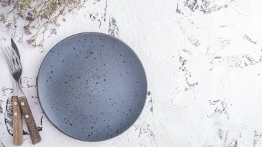 Fortk ve bıçakla servis edilen boş yuvarlak tabak. Üst görünüm, metin alanı