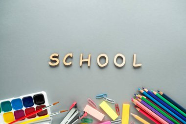 Okul malzemeleri gri arka planda. Üst görünüm, okul konseptine geri dönüş. 