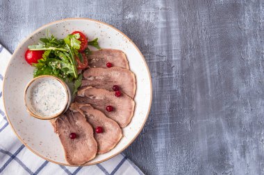 Dilimlenmiş sığır dili, salata ve beyaz soslu soğuk aperatif. Üst Manzara. Boşluğu kopyala