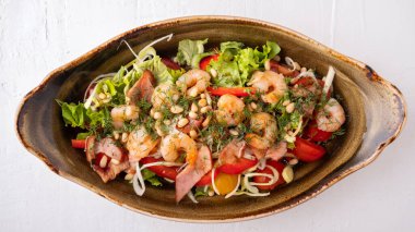 Kızarmış pastırmalı, sebzeli ve çam fıstıklı karides salatası. Üst görünüm