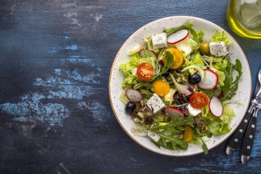 Sebzeli, peynirli ve zeytinli taze salata. Diyet ve sağlıklı gıda konsepti. Üst görünüm, metin alanı
