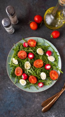 Arugula ile diyet salatası, quaill eqqs ve vişneli domates. Sebze salatası tabakta. Üst görünüm 