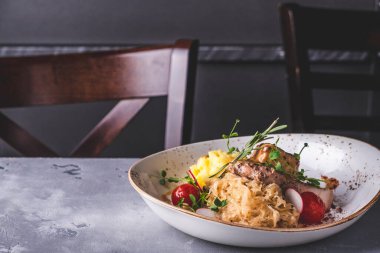 Kızarmış domuz eti, lahana turşusundan garnitür ve patates püresi.