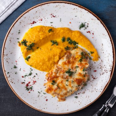 Peynirin altında fırında tavuk ve havuç püresi. Üst Manzara. Yakın çekim.