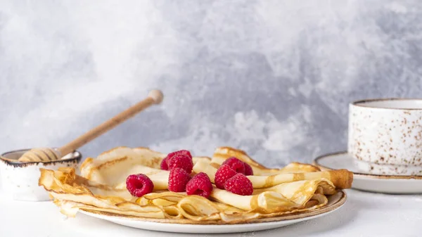 Crepe with raspberries and honey. Tasty breakfast concept. Text space