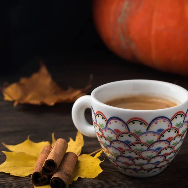 Coffee cup on autumn leaves  over wood background. Autumn coffee cup