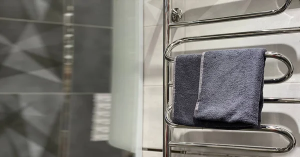 浴室里毛巾烘干机上的灰色毛巾 复制空间 — 图库照片