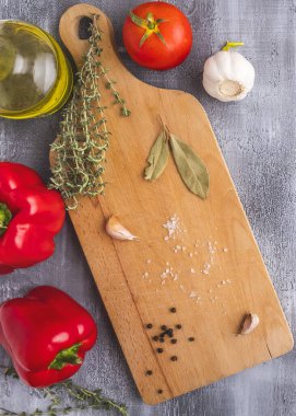 Ahşap kesme tahtasında yemek ve baharatlar için malzemeler var. Üst görünüm