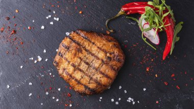 Siyah taşın üstünde sulu ızgara biftek. Üst görünüm.