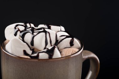 Marşmelovlu kahve. Lezzetli sıcak bir içecek, siyah bir şekerleme.