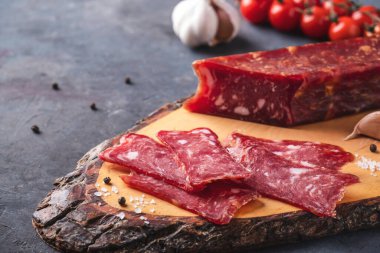 Tahta kesme tahtasında dilimlenmiş salam..