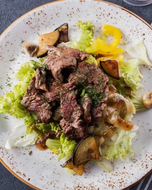 Sebzelerle süslenmiş ızgara dana eti. Lezzetli sığır salatası. Üst Manzara. Yakın çekim.