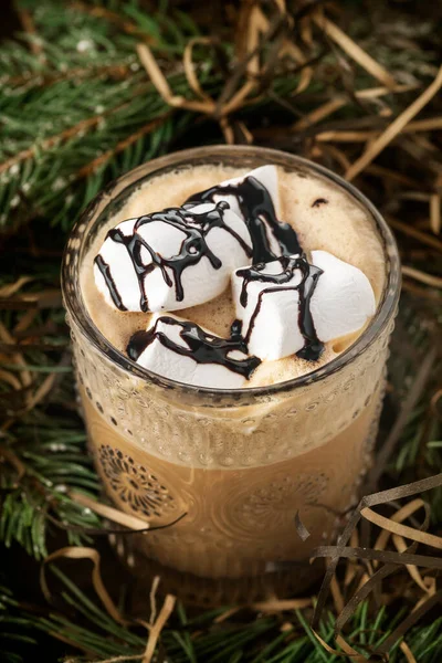 Coffee with marshmallow. Hot coffee with marshmallows in spruce branches. Closeup
