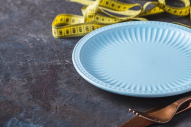 Boş mavi plaka ve mezura. Kilo verme konsepti. Sağlık Hizmetleri