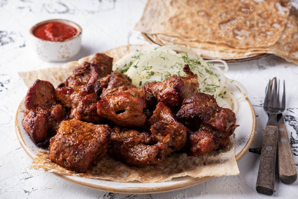 Grilled shish kebab on a plate serbed with fork and knife