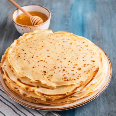 Ballı bir tabakta ince krepler. Yakın çekim..