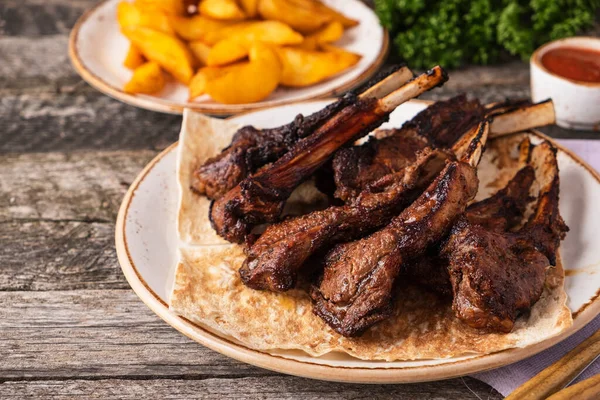 Grilled lamb chops on a plate. Mutton on a grill. Copy space