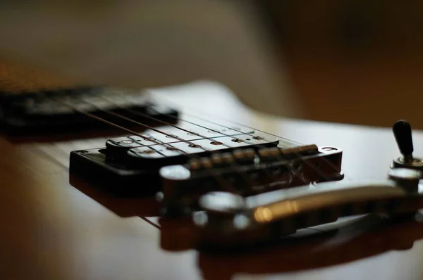 Streams and Bridges. Closeup shot of Washburn Idol WI-64 electric guitar with Tune-o-matic bridge