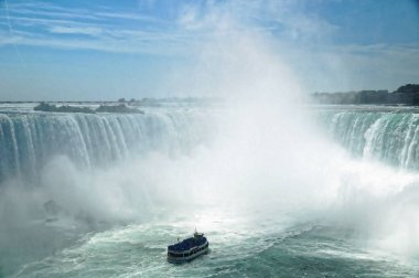 Niagara Horseshoe Falls turistik gemi yaklaşıyor sis hizmetçi ile. Düşme yüksekliği 57 m ve saniyede yaklaşık 6.400 m3 su aşağı atmak