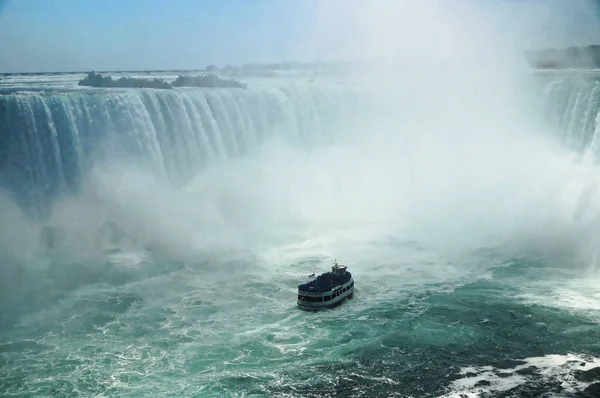 Niagara Falls podkowa z statek turystyczne pokojówka zbliża się mgły. Wysokość falls jest 57 m i one rzucać około 6400 m3 wody na sekundę — Zdjęcie stockowe