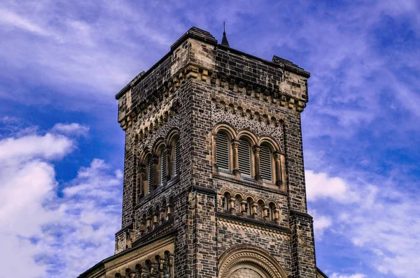 Oude gotische toren voor bewolkte blauwe hemel — Stockfoto