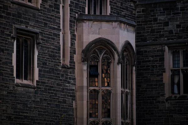 저녁 황혼에 돌 벽과 유럽 풍의 창문이있는 오래된 고딕 양식의 건물 외관 — 스톡 사진