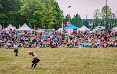 Fergus, Ontario, Kanada - 08 11 2018: Geleneksel İskoç ağır otları yarışmalarında kilt giyen atlet Fergus İskoç Festivali ve Highland sırasında bir Caber Toss yarışmasında becerilerini sergiliyor