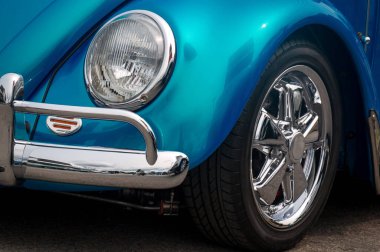 Dış yüzeyin ön tarafı, tekerlek, çamurluk, tampon, kaput, eski mavi arabanın ön ışığı..