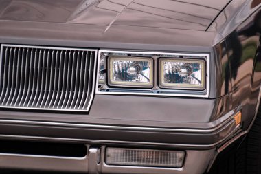 Dış kısmının ön tarafı ızgara, çamurluk, tampon, kaput, far, gri eski model kronometre ışığı..