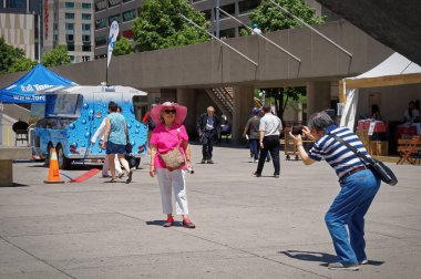 TORONTO, CANADA - 06 27 2016: Toronto Nathan Phillips Meydanı 'nın ana meydanında fotoğraf çeken bir turist çifti, Kanada' nın büyük kentlerinde kalışlarını anmak için